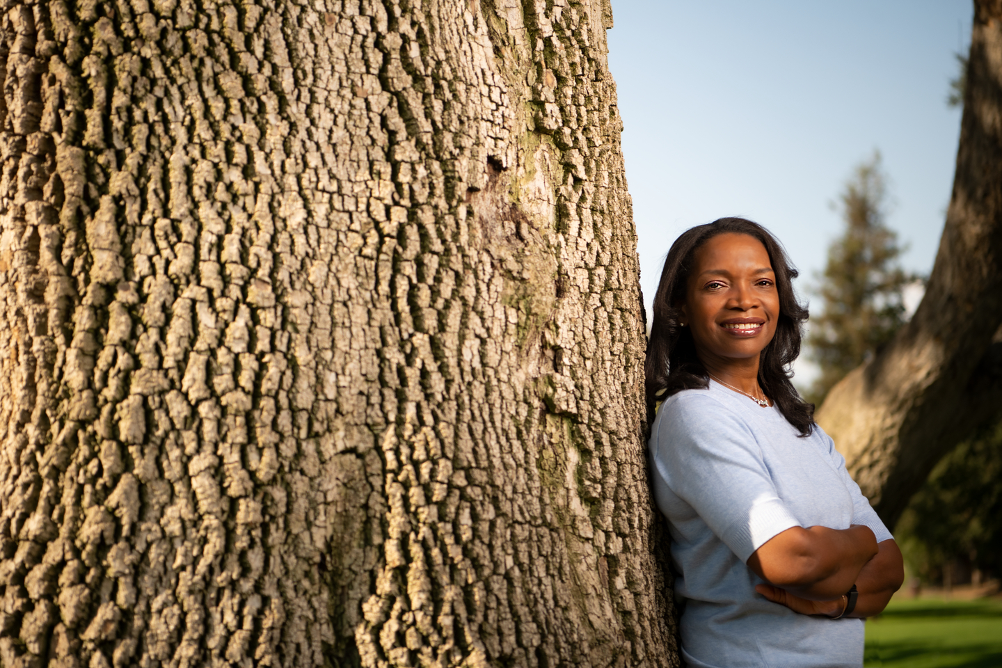 Bentley trustee Pauline Callender Han ‘91 leaning against tree with arms crossed