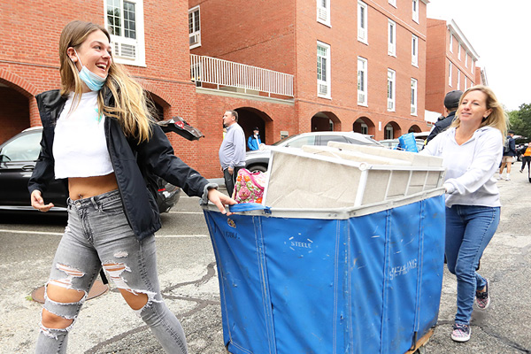 Mother and daughter with a cart of belongings