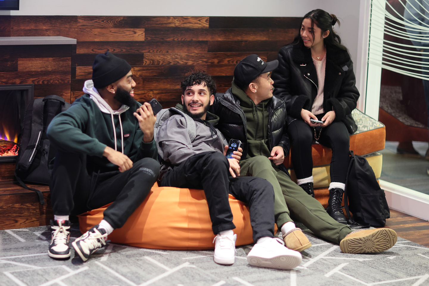 A group of four Bentley students on bean bag chair in the Multicultural Center Lounge