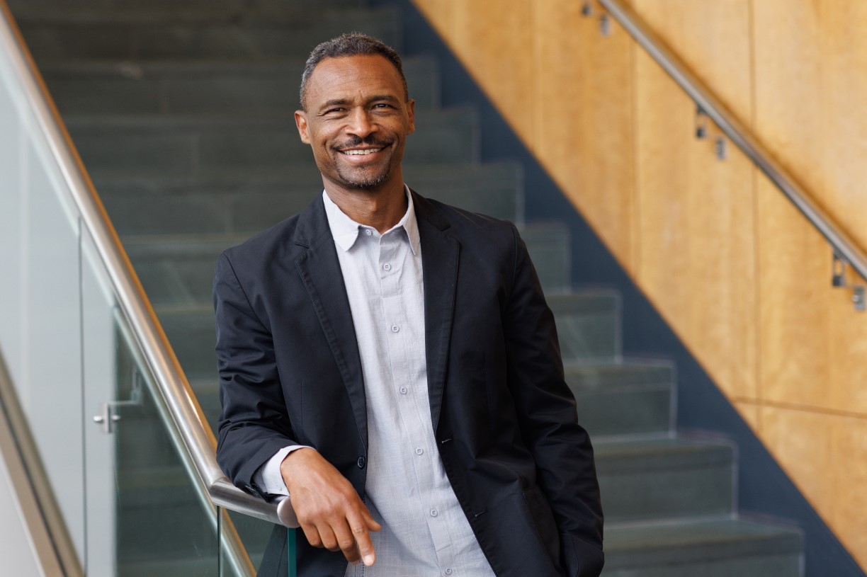 João Resende-Santos, an associate professor of international studies, stands at the foot of a staircase in Smith Hall, his right arm resting atop the banister. 