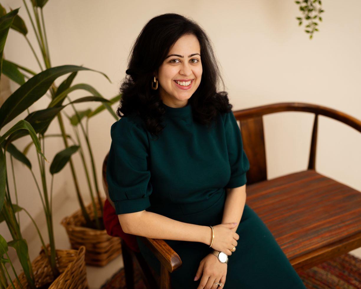 Saloni Borar sitting on a bench with a plant in the background