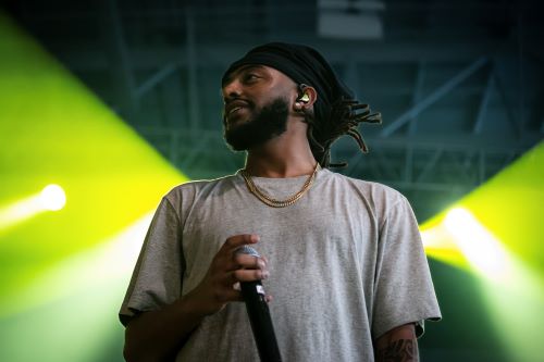 Amine on stage holding a microphone