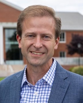 Headshot of Provost Paul Tesluk, in gray suit