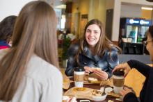 happy student eating with her friends