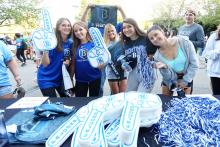 Female students at the football game with signage