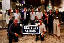 Group of alumni posing with banner that reads Bentley Alumni