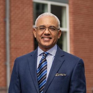 Headshot of President E. LaBrent Chrite, in a blue suit and striped blue tie.