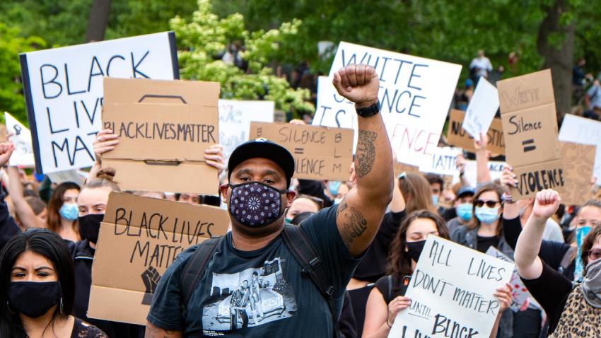 Black protestors in a march with signs