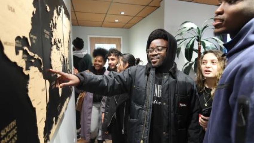 Bentley students gather around world map in Multicultural Center Lounge