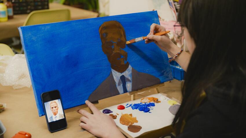 Participant painting art on canvas at the Bentley MLK social justice program.