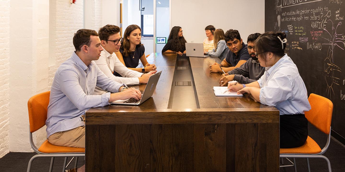 people sit and work at a table