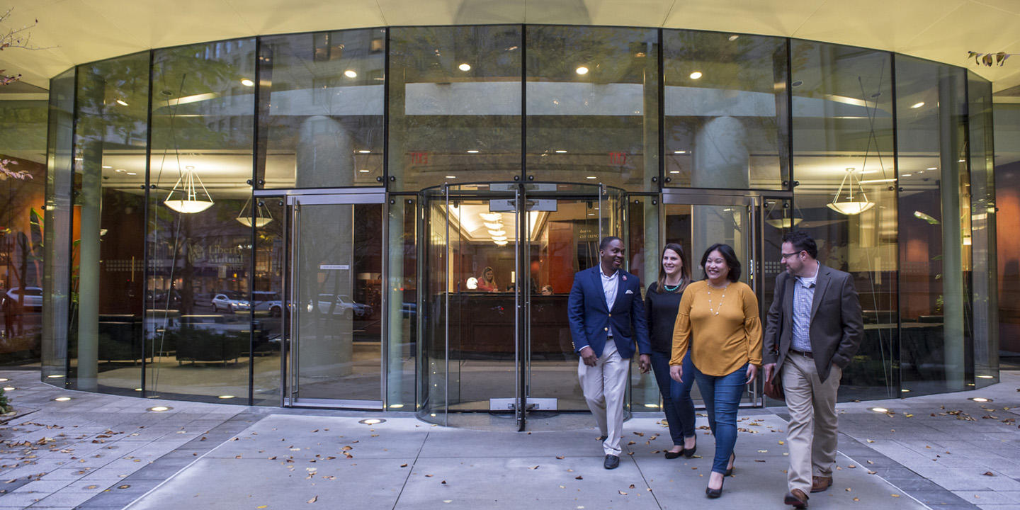 four professionals walk in downtown boston