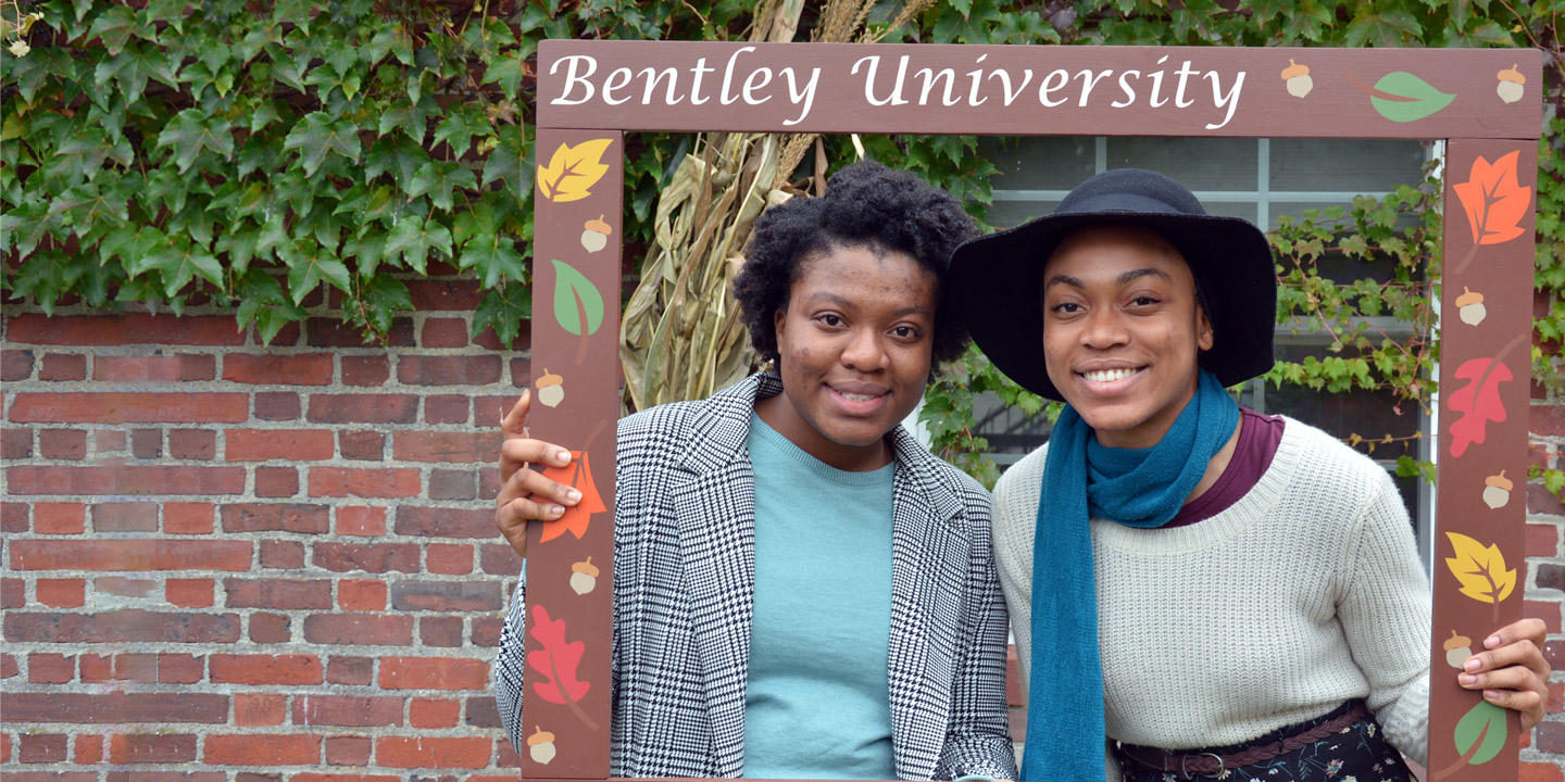 a parent and a student pose for the camera on campus