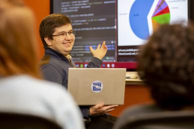 Cem Özsümer '23 tutoring students in the CIS Sandbox with a computer