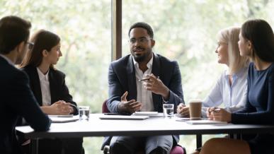 Diverse group of business professionals sitting at a table talking