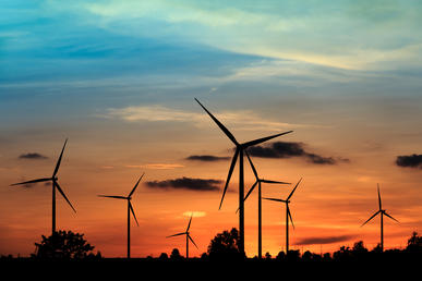 Wind farm against orange sky